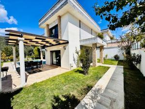 a white house with a patio and a table at Villa Bella in Kusadası