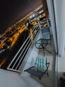 a balcony with two chairs and a view of a city at HERMOSO DEPTO COND MARINA SOL Lado CASINO ENJOY in Coquimbo