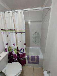 a bathroom with a toilet and a shower curtain at HERMOSO DEPTO COND MARINA SOL Lado CASINO ENJOY in Coquimbo