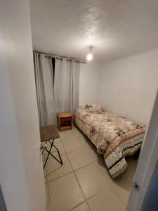 a bedroom with a bed and a table in it at HERMOSO DEPTO COND MARINA SOL Lado CASINO ENJOY in Coquimbo