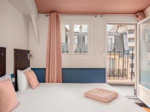 ein Schlafzimmer mit einem großen Bett und einem Fenster in der Unterkunft Hôtel Biskui in Levallois-Perret