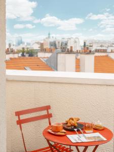 - une table avec un plateau de nourriture sur le balcon dans l'établissement Hôtel Biskui, à Levallois-Perret