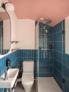 La salle de bains est pourvue de toilettes, d'un lavabo et d'une douche. dans l'établissement Hôtel Biskui, à Levallois-Perret