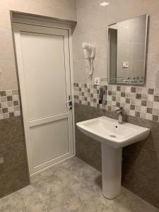 bagno con porta bianca e lavandino di Cherqe Guest House a Sighnaghi