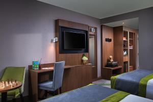 クロランにあるカールトン ホテル ダブリン エアポートのベッド、デスク、テレビが備わるホテルルームです。