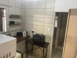 a small kitchen with a table with a radio on it at Pringle Cottage in Benoni +4 photos