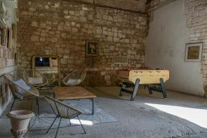 a room with a ping pong table and chairs at Le Relais du Beffroi & SPA in Saint-Riquier