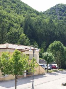 a building with trees in front of a mountain at Joli T2 climatisé 70 dans un écrin de verdure 04000 in Digne-les-Bains