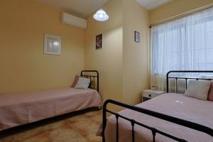 Una pequeña habitación con dos camas y una ventana. en Paralia Comfort House, en Paralia Katerinis