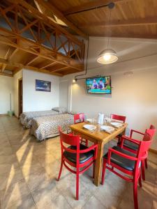uma sala de jantar com uma mesa e cadeiras e uma cama em Choconcito Apart Hotel em Ushuaia