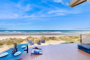 a wooden deck with chairs and the beach at Pacific Dream in Neskowin