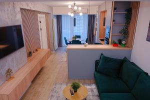 un soggiorno con un divano verde e una cucina di AtmoSphere Apartment by Infinity Resort & Spa a Mamaia Nord - Năvodari