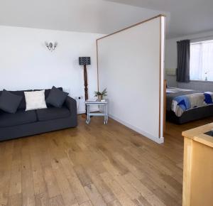a living room with a couch and a bed and a mirror at The Annex - Penzance town centre with parking in Penzance