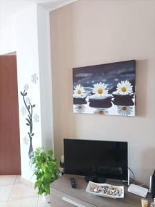 Una sala de estar con un televisor y una mesa. en Casa MALU', en Cavallino di Lecce