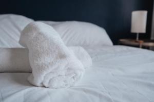 a stack of towels sitting on top of a bed at Comfy 3BR Home - Pool Table - Games - Sleeps 8 in Manchester +27 photos
