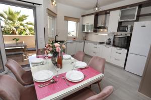 a kitchen and dining room with a table and chairs at New,Modern apartment near Split andTrogir in Kaštela