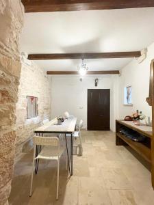 una sala da pranzo con tavolo e sedie di Nidadi Trulli d'Itria a Martina Franca