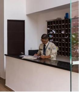 a man standing at a counter in an office at Edificio La Frontera - Vista El Poblado Free Parking & Wifi Recep 24 h in Medellín