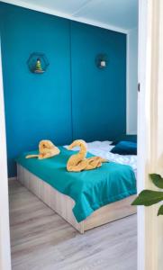 Un dormitorio con una cama con dos cisnes de madera. en Panoráma Vendégház, en Tahitótfalu
