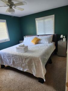 1 dormitorio con 1 cama con paredes verdes y ventilador en The Legacy Home, en Midland