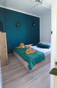sypialnia z 2 łóżkami pojedynczymi i niebieskimi ścianami w obiekcie Panoráma Vendégház w mieście Tahitótfalu