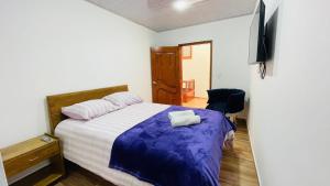 - une chambre avec un lit et une télévision dans l'établissement Villa Mongui, à Monguí