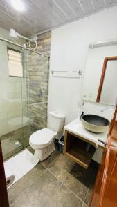 La salle de bains est pourvue de toilettes, d'un lavabo et d'une douche. dans l'établissement Villa Mongui, à Monguí
