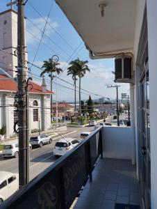 a balcony with a view of a street with cars at Suìte Madagascar in Penha