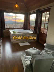 uma sala de estar com uma banheira e um sofá em Chalé Mirante do Sol em Ouro Preto