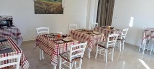 jadalnia z 2 stołami i białymi krzesłami w obiekcie B&B Villa Bello w mieście Otranto