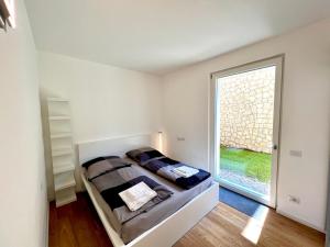 1 dormitorio con cama y ventana grande en Seeblick Le Dimore en Malcesine