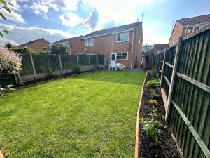 um quintal com uma cerca e um jardim de relva em Hinckley Home Sleeps 5 Complete House em Leicester