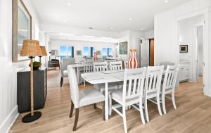 a dining room with a white table and chairs at Queen Of Crystal Shores Luxury Beachfront Retreat in Destin