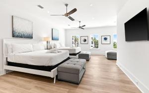 a bedroom with two beds and a flat screen tv at Queen Of Crystal Shores Luxury Beachfront Retreat in Destin +32 photos