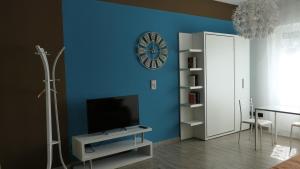 a living room with a blue wall with a clock at Pole Position Rho - Milano a portata di mano in Rho