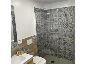 a bathroom with a shower with a toilet and a sink at La Valigia sul letto in Mesagne