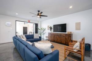 a living room with blue couches and a flat screen tv at Zion Haus in Hurricane