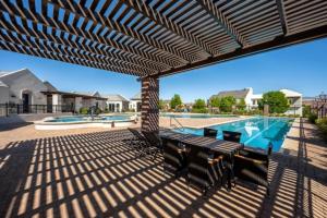 a patio with a table and chairs and a swimming pool at Zion Haus in Hurricane