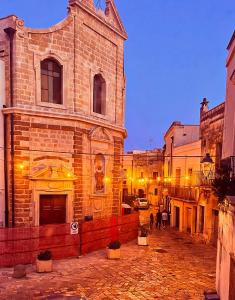 an old brick building with people walking in front of it at La Valigia sul letto in Mesagne