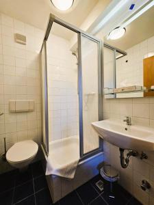 een badkamer met een douche, een toilet en een wastafel bij Novitel Pension Pliening - München Messe in Pliening