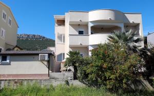a white building with a palm tree in front of it at New,Modern apartment near Split andTrogir in Kaštela
