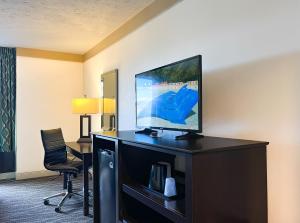 ピジョン・フォージにあるCountry Cascades Waterpark Resortの薄型テレビ、椅子が備わるホテルルームです。