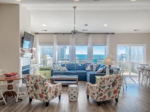 a living room with a blue couch and chairs at LegaSea in North Topsail Beach
