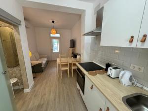 a kitchen with a counter top and a living room at Apartamento Búho - Junto al Castillo in Antequera