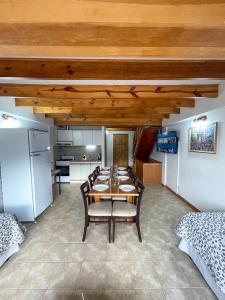 comedor con mesa y sillas y cocina en Choconcito Apart Hotel en Ushuaia