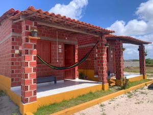 a brick house with a hammock outside of it at Chalé Cantinho do Céu- Santo Amaro do MA in Santo Amaro