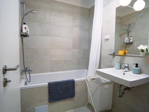 a bathroom with a sink and a bath tub at Relaxing Coresi Studio in Braşov +56 photos