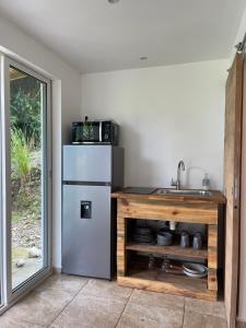 a kitchen with a sink and a refrigerator at Villa Kayooli in Trois-Rivières