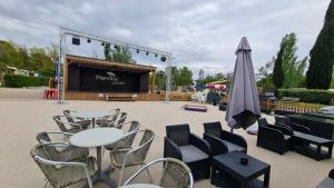 卡代纳Mobil Home au calme Camping 4 Cadenet的一张桌子、几把椅子、一个舞台和一把遮阳伞