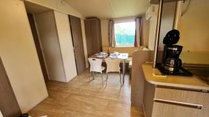 卡代纳Mobil Home au calme Camping 4 Cadenet的房间里有一张桌子和几把椅子的厨房
